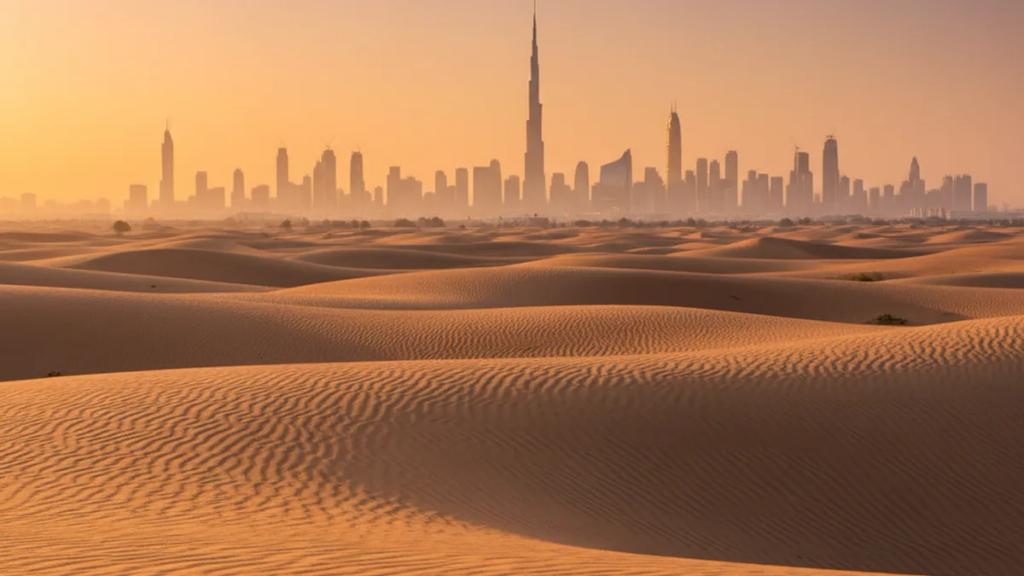 Alacakaranlıkta Dubai silüetinin önünde, telefonundaki bağlı mobil sinyali kontrol eden İngiliz bir gezgin