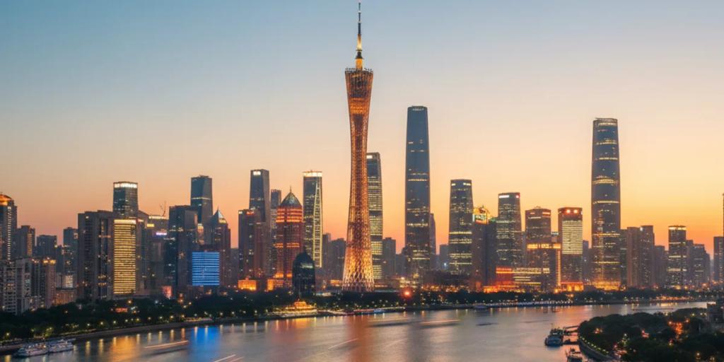 Gece İnci Nehri üzerinde renkli ışıldayan Canton Tower, arkasında Zhujiang New Town silueti