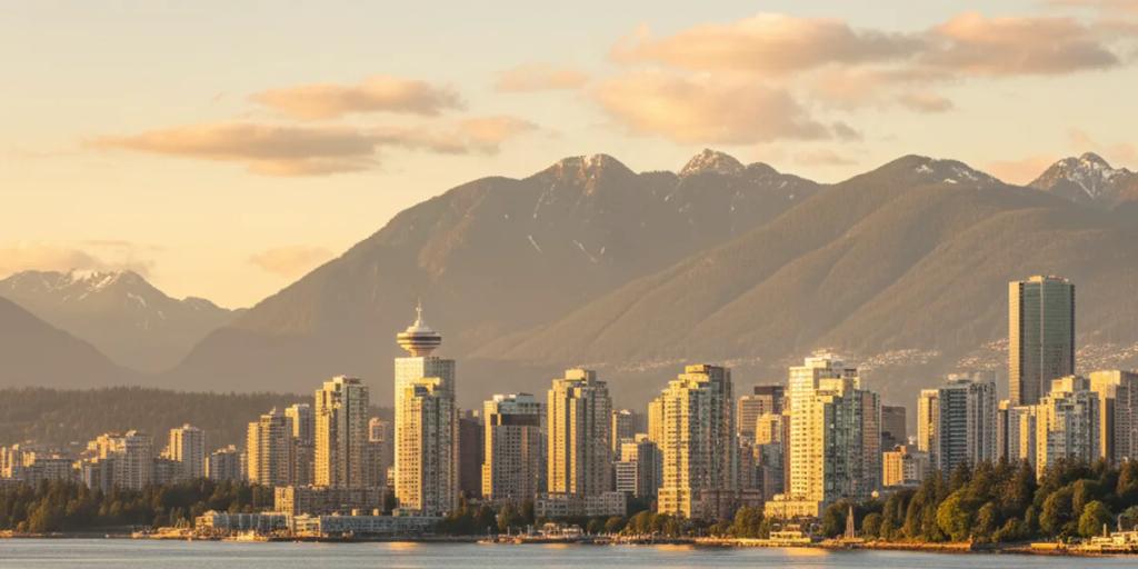 Coal Harbour'da suya inen deniz uçakları ve arkada yükselen North Shore dağlarıyla Vancouver'ın camdan silüeti