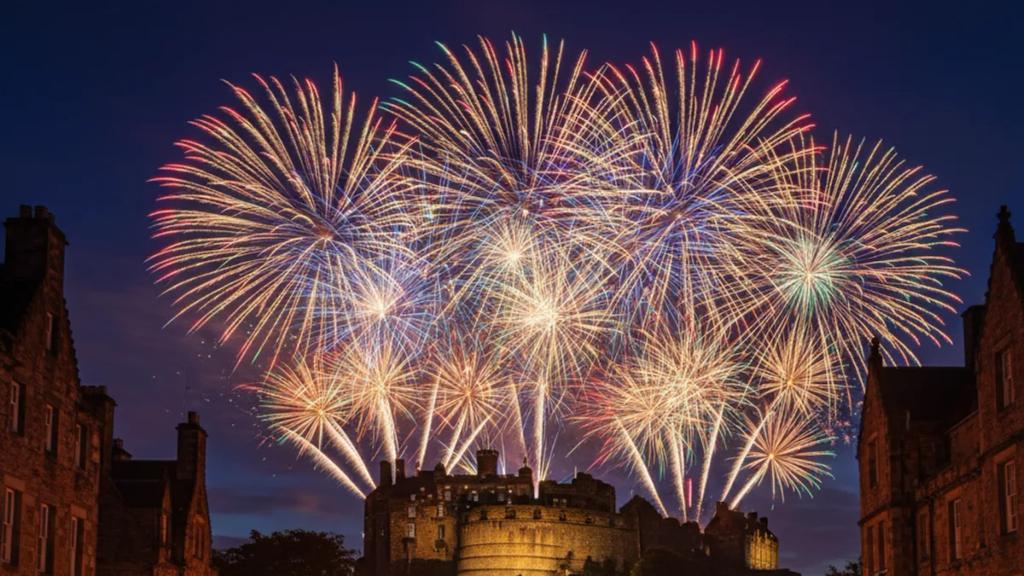 Hogmanay sırasında tıklım tıklım dolu Princes Street'in üzerinde, Edinburgh Kalesi'nin ardında patlayan gece yarısı havai fişekleri